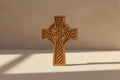 Wooden Celtic cross with intricate carvings on a white background
