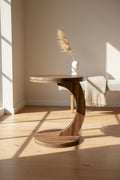 Wooden side table on a wooden floor with a sofa in the background